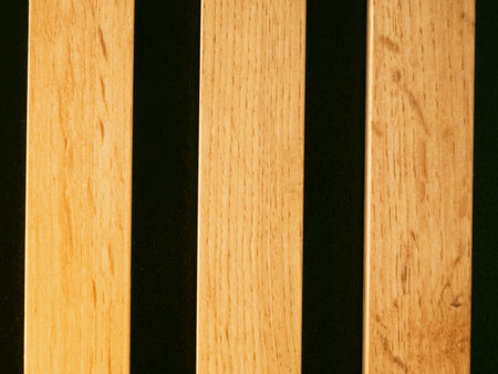 Three vertical wooden planks stand against a deep black background. Natural grain patterns run...