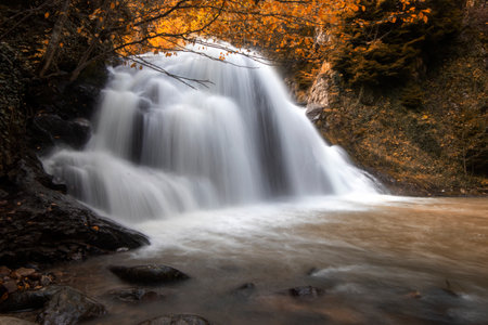 Long exposure of a waterfall in the autumn forest. Long exposure.
