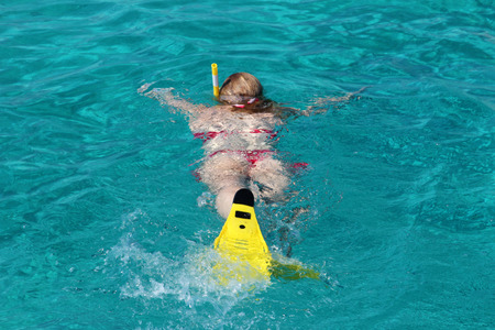 Beautiful young girl snorkeling in the oceanの写真素材