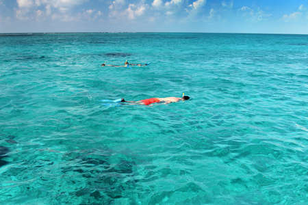Young man snorkeling in a group of other peopleの写真素材