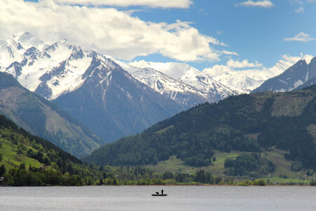 Fishermen on the Zeller See with beautiful mountains in the backgroundの写真素材