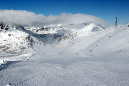 Beautiful scenery groomed slopes, snow-capped peaks of the Austrian Alps in the backgroundの写真素材