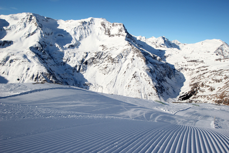 Beautiful scenery groomed slopes, snow-capped peaks of the Austrian Alps in the backgroundの写真素材