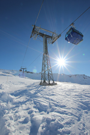 Gondola lift in the Austrian Alps with the sun in the backgroundの写真素材