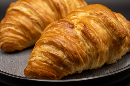 Freshly baked croissants on a black plate, close upの写真素材