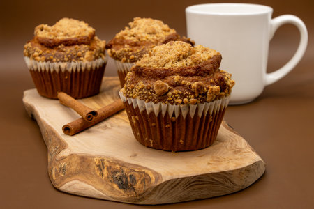 Coffee cup and muffins with cinnamon on a wooden boardの写真素材