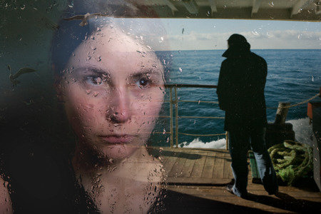 young woman in depression near the windowの写真素材