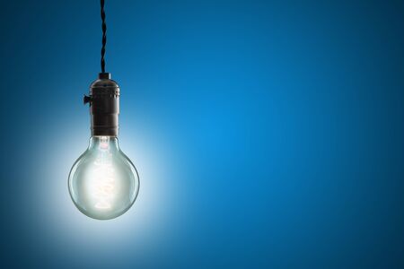 Idea concept -  incandescent bulb on blue backgroundの写真素材