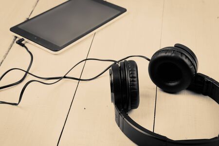 Music online concept - phablet and headphones on the wooden desk