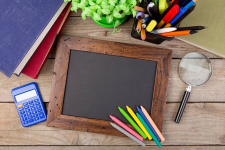 school supplies and blackboard with copy space on tableの写真素材