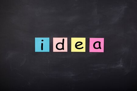 Business concept - Word 'Idea' written on color stickers on the chalkboardの写真素材