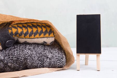 gifts - warm sweaters in a paper bag and sale signboard, copy space for text