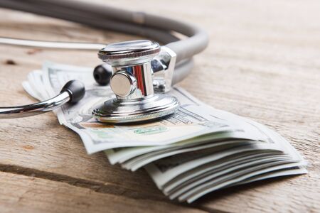 health insurance concept - stethoscope over the money on the tableの写真素材
