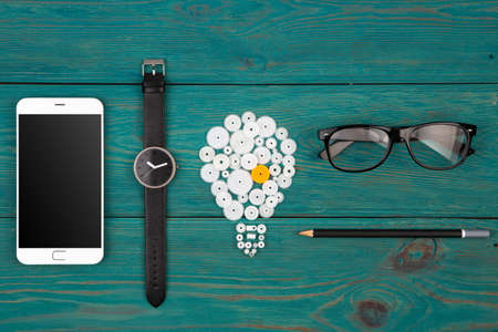 idea concept - bulb sign, glasses, watch and phone on the desk