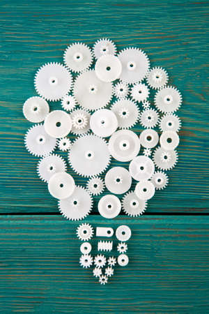 Idea concept - bulb composed of the gears on the wooden deskの写真素材