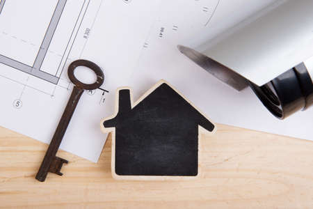 Real estate security or insurance concept - little house model, old keys and surveillance cctv...