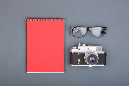 Journalist or blogger table spiral blank notebook, pencil and glasses on gray background, top viewの写真素材