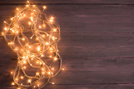 party lights decoration. Wooden background with christmas lights garlandの写真素材