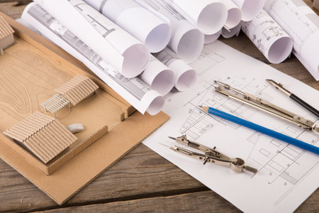 Workplace of architect - construction drawings, scale model of a house and tools
