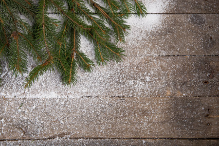 Christmas fir tree with snow on wooden board backgroundの写真素材