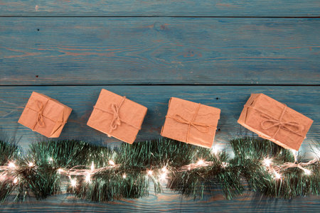 Christmas gifts and lights on the wooden background