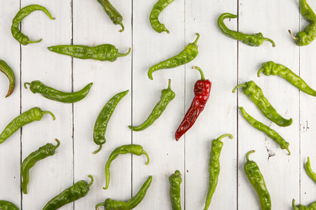 Leadership concept - red hot chili pepper leading the group of green peppersの写真素材