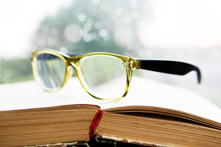 glasses and book on rainy windowの写真素材
