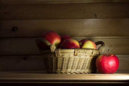 Basket with ripe, beautiful apples on a wooden background.の写真素材