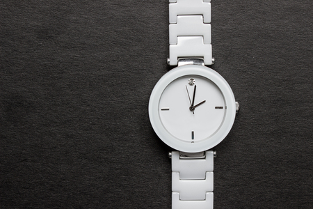 White clock with diamond and white bracelet. Close-up on a black background.の写真素材