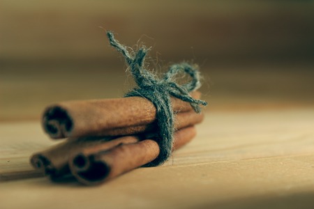 Cinnamon tied with a thread of wool close-up on a wooden background.の写真素材