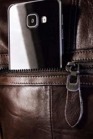 Mobile smartphone in a bag pocket with a lock.の写真素材