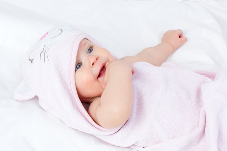Blue Eyes Cute Tiny baby girl wrapped in a soft pink kitty towelの写真素材