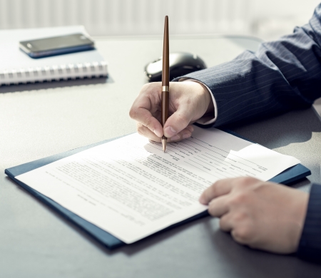 Financial planning specialist signing annual report in officeの写真素材