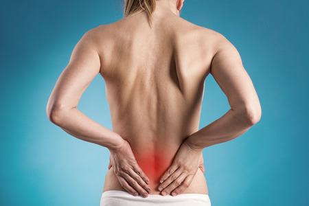 Muscle cramp or backache on naked woman s back  Young female touching her painful back 