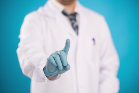 	Male surgeon in surgical gloves pointing somethingの写真素材