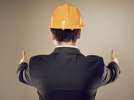 Portrait of male engineer in yellow helmet showing thumbs up  Young successful construction manager...