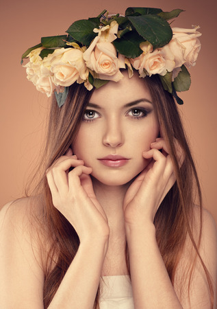 Close-up portrait of summer teenage girl with flower hairstyle. Young lovely Caucasian woman model with professional make-up and hairdo posing in studio.の写真素材