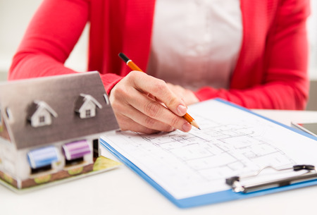 Young female designer drawing house plan for reconstruction. Architectural project concept. Shallow depth of field.の写真素材