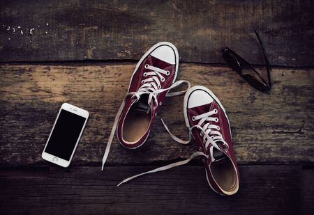 Top view of stylish girl outfit: gumshoes, sunglasses and smartphone. Concept of modern lifestyle and travel.の写真素材