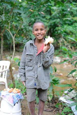 Samana, Dominican Republic,  December 28, 2010 - A boy selling conch shells to tourists in Samana, Domican Republic.のeditorial素材