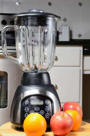 Blender with whole raw fruit with a kitchen background.の写真素材
