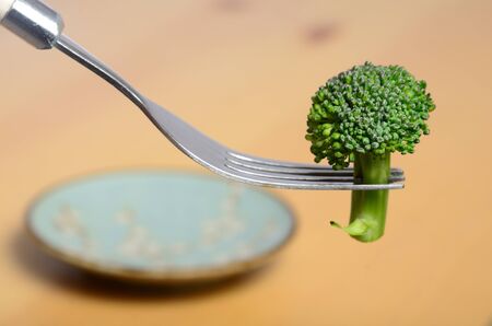 broccoli on a fork above a plateの写真素材