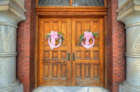 Church doors with pink wreathsの写真素材