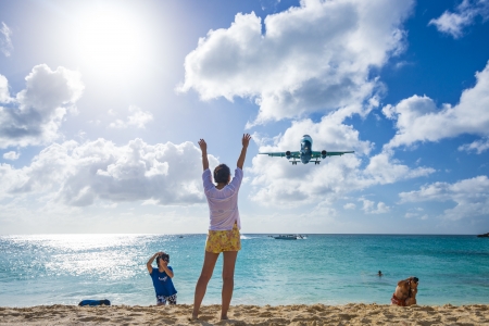 PHILIPSBURG, SINT MAARTEN - DECEMBER 30, 2013: A commercial jet approaches Princess Juliana airport above onlooking spectators. The short runway gives beach goers close proximity views of the planes.のeditorial素材