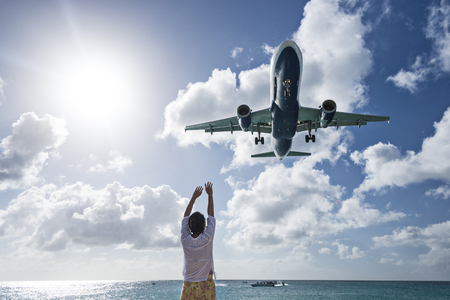 PHILIPSBURG, SINT MAARTEN - DECEMBER 30, 2013: A commercial jet approaches Princess Juliana airport above onlooking spectators. The short runway gives beach goers close proximity views of the planes.のeditorial素材