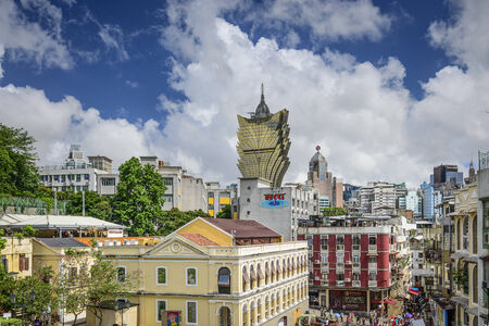 MACAU, CHINA - MAY 21, 2014: Tourists stroll under the skyline of Macau. The city is the world's...
