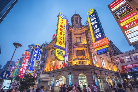 SHANGHAI, CHINA - JUNE 16, 2014: Neon signs lit on Nanjing Road. The street is the main shopping...