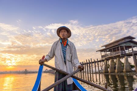 MANDALAY, MYANMAR - OCTOBER 28, 2015: A Gondolier paddles on Taungthaman Lake at U-Bein Bridge.のeditorial素材