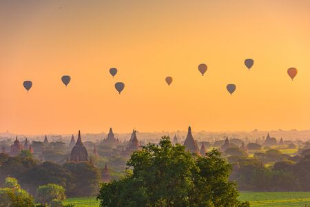Bagan, Myanmar ancient temple ruins landscape in the archaeological zone at dawn with hot air balloons.の写真素材