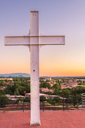 Santa Fe, New Mexico, USA cross and downtown skyline at dusk.